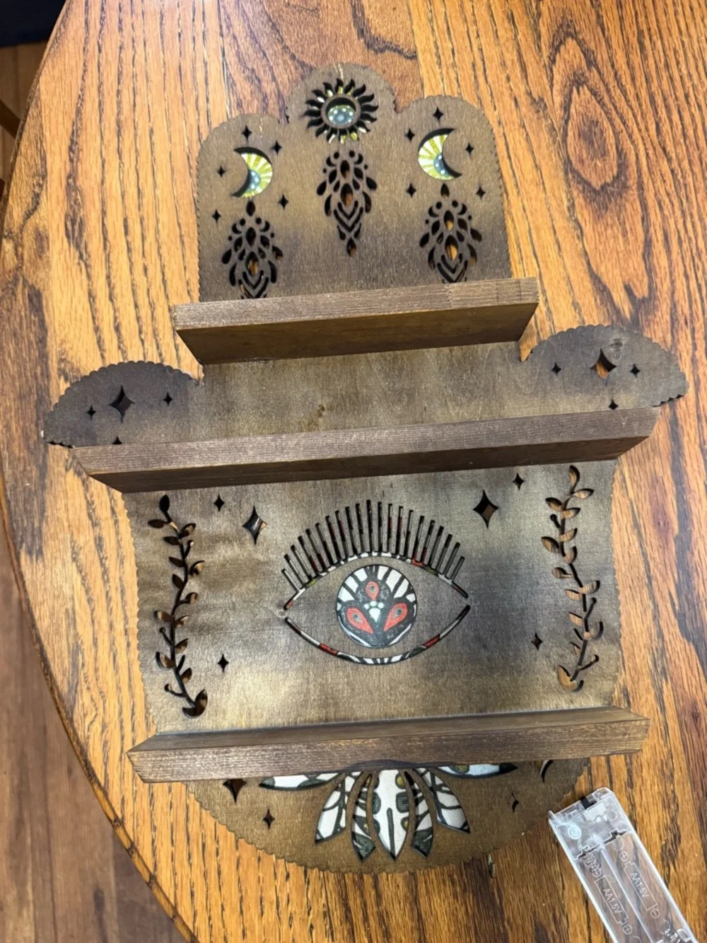 Handcrafted Brown Wooden Wall Shelf with Decorative Eye Motif that lights up